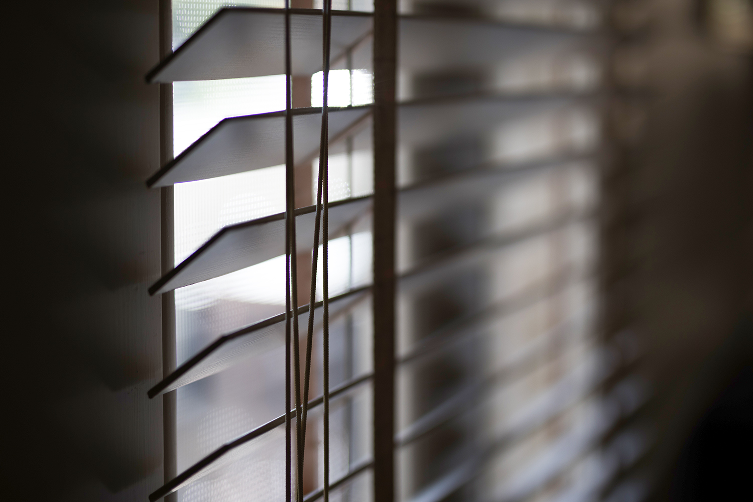 Timber venetian blinds on window casting shadows