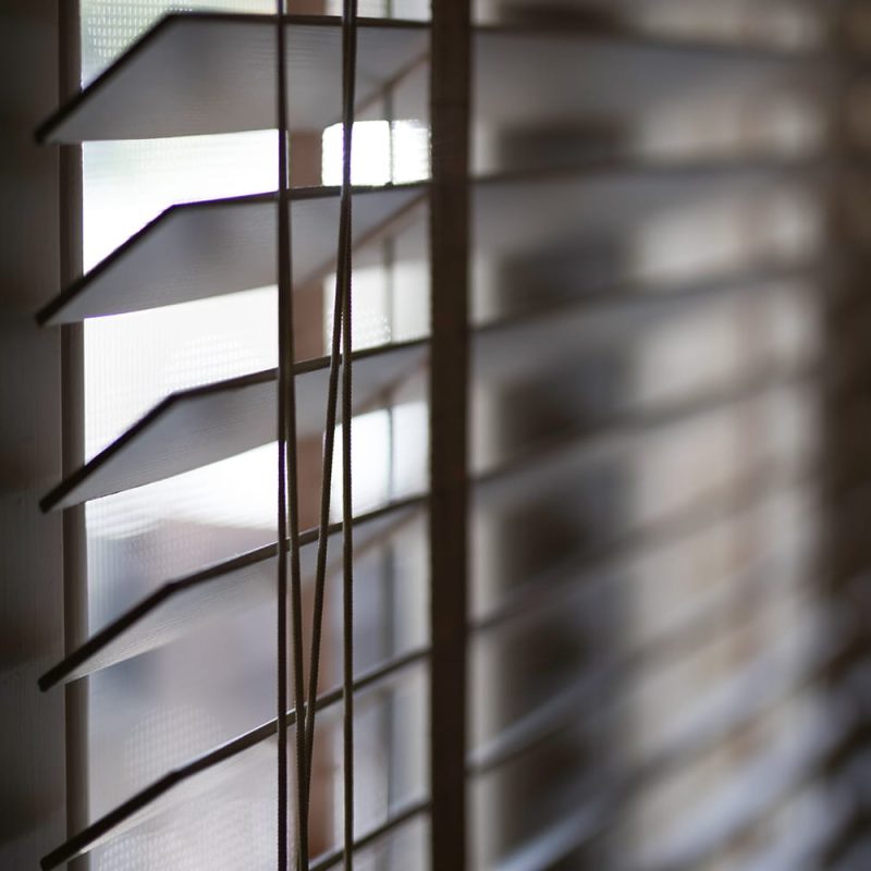 Timber venetian blinds on window casting shadows